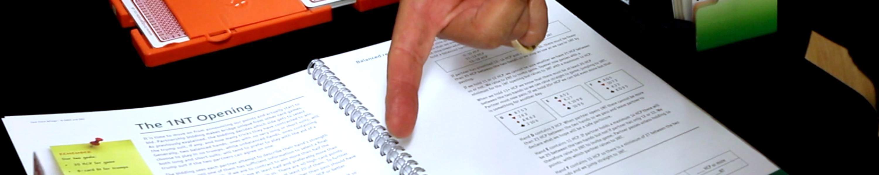 Hand pointing at bridge teaching book